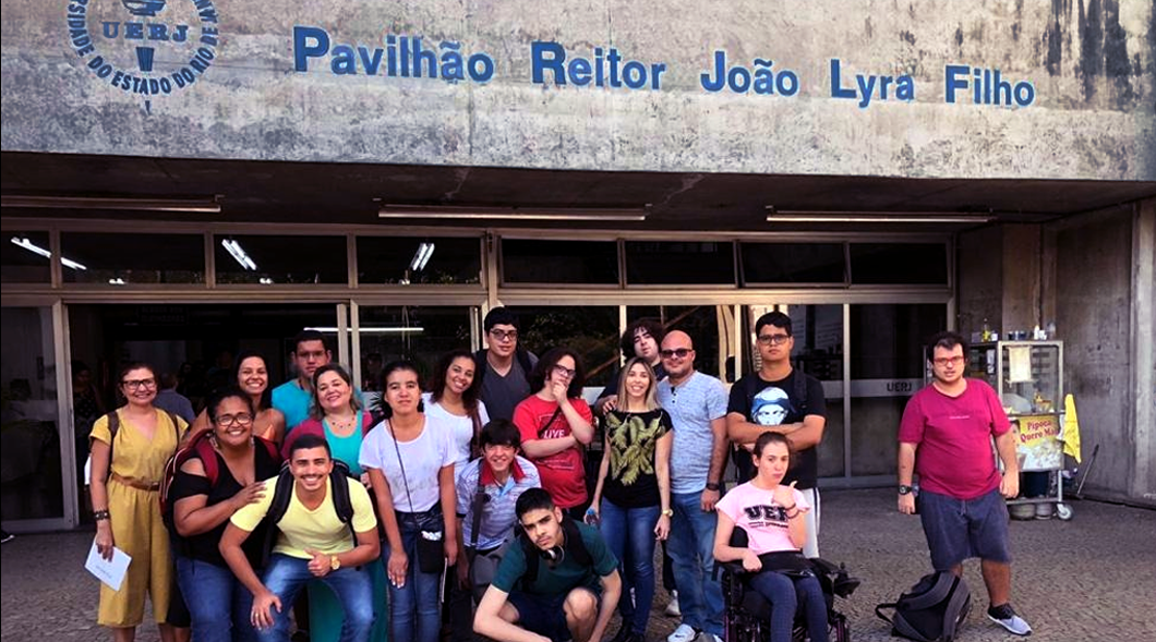 Foto de grupo com alunos com deficiência na entrada do prédio da Uerj no Campus Maracanã