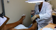 Profissional de jaleco branco e luvas aplica tratamento em pés de paciente